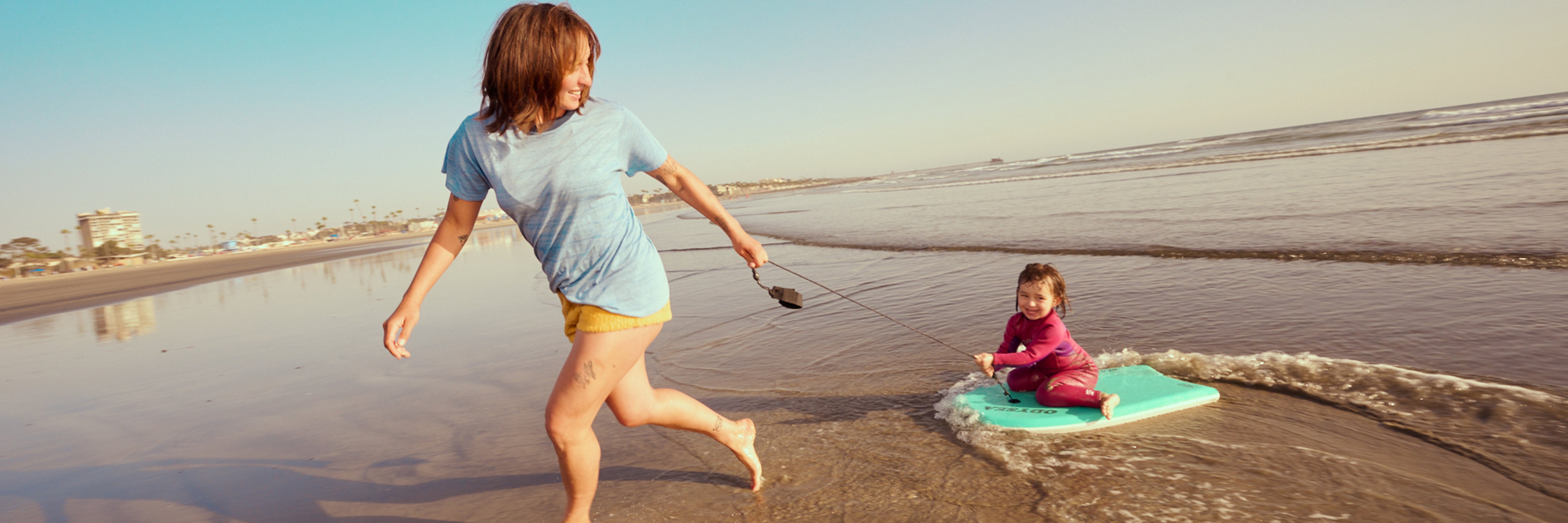 Two children playing on a beach with a clear sky
