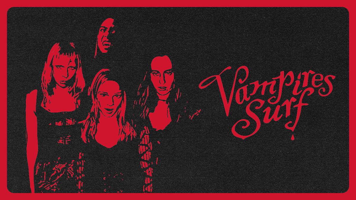 A black graphic print featuring a red distressed design with a witch's hat and castle silhouette under a red full moon, three stylized faces, and the text 'Vampires Surf' in red script.