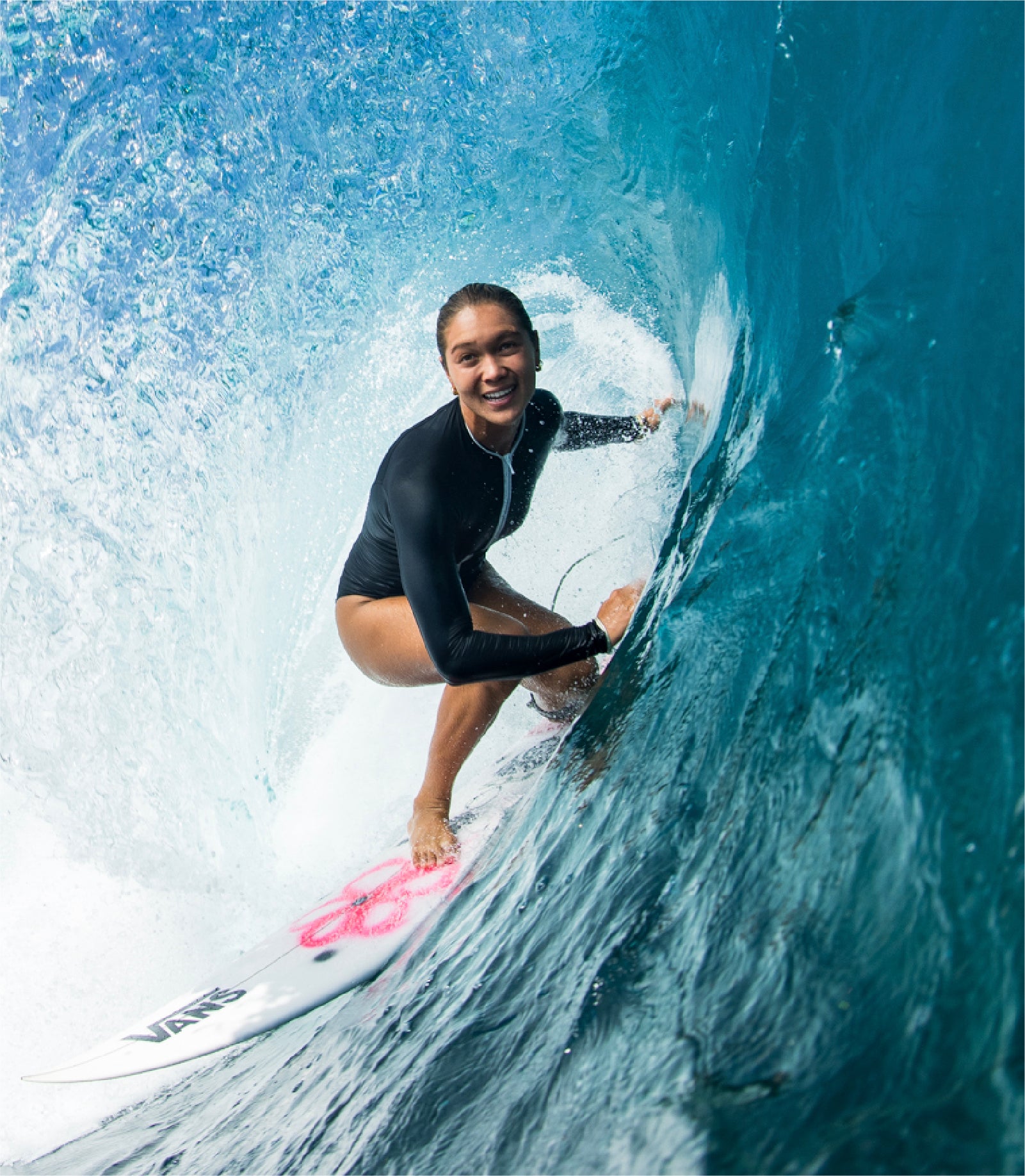 Person surfing on a wave with a Vans surfboard