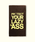 Brown towel with yellow text 'PROTECT YOUR LAZY ASS' on a white background