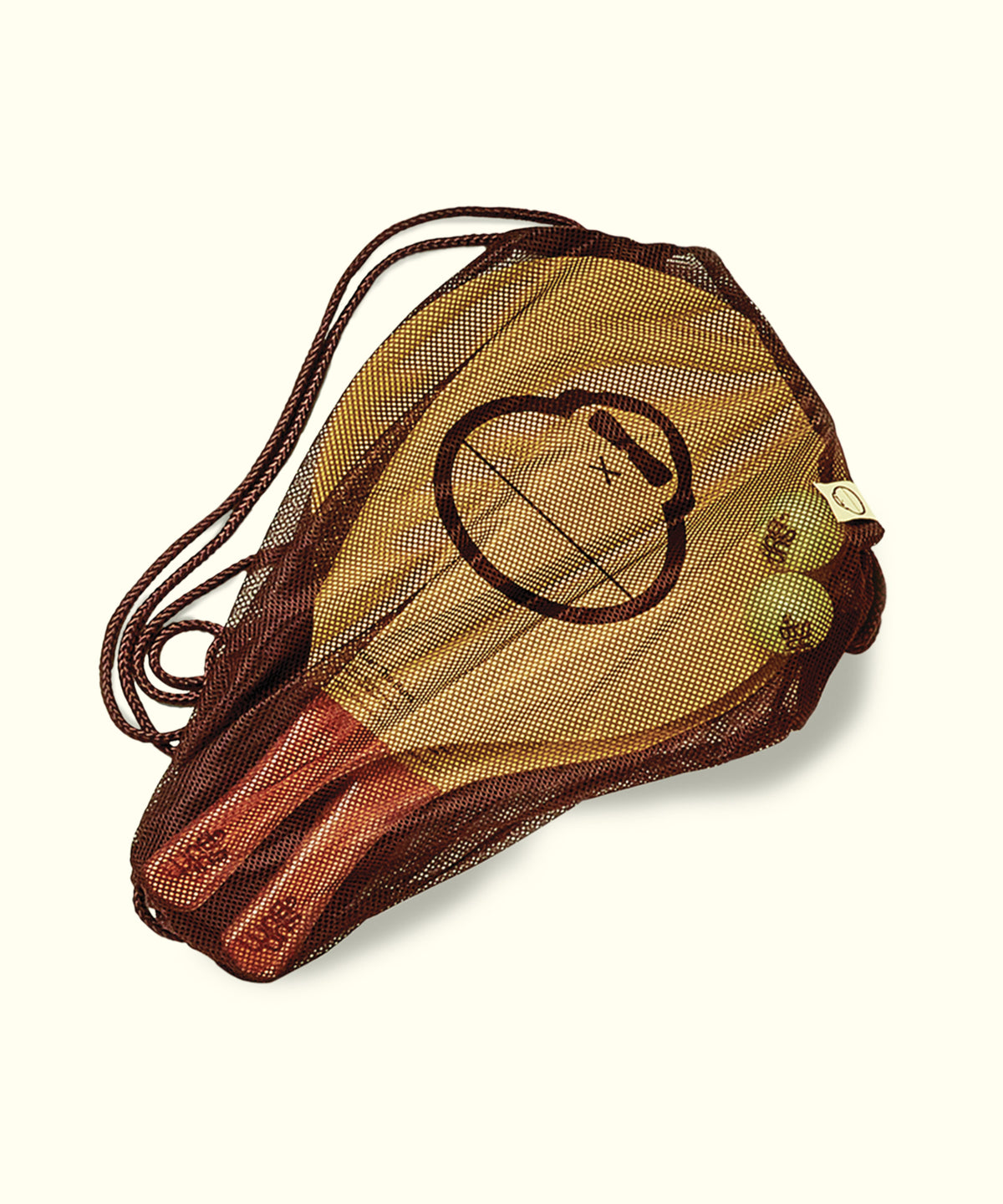 Wooden paddle with a face design in a mesh bag on a white background
