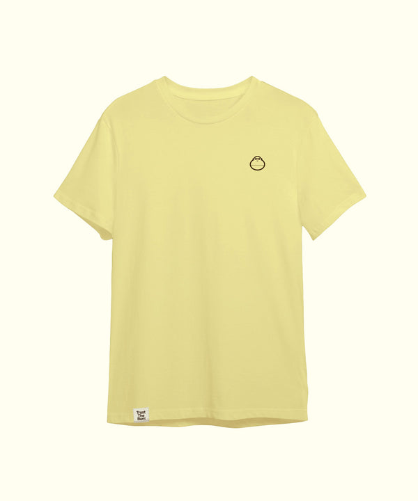 Light yellow plain tee featuring a small, minimalistic mascot logo on the left chest, perfect for casual wear. Sun Bum.