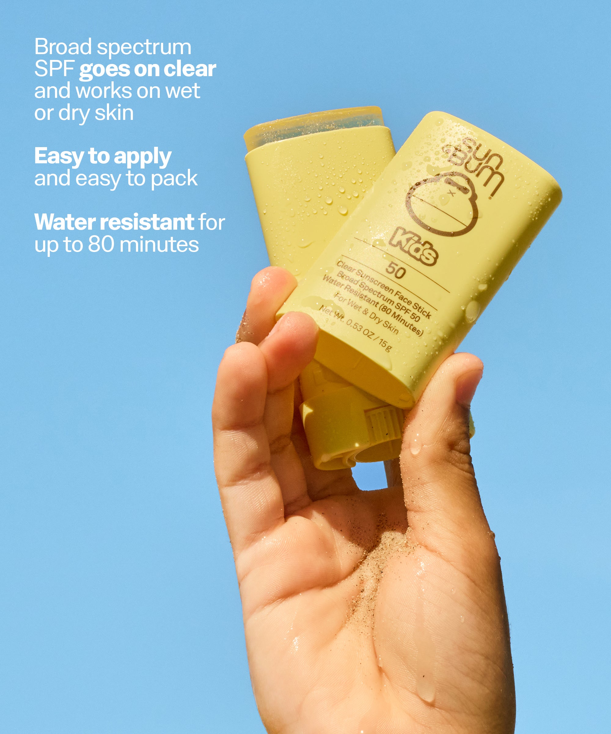 Hand holding a yellow sunscreen bottle with text about its features on a blue background
