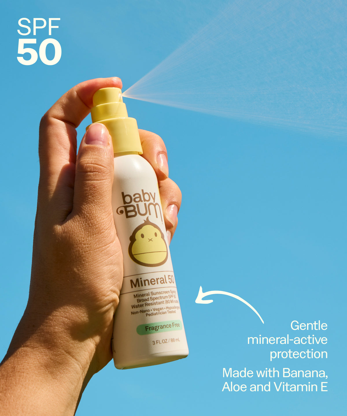 Hand holding a baby sunscreen spray bottle with blue sky background