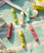 Collection of colorful lip balms on a textured surface