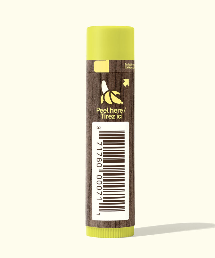Lip balm with a banana label and peel here instruction on a white background