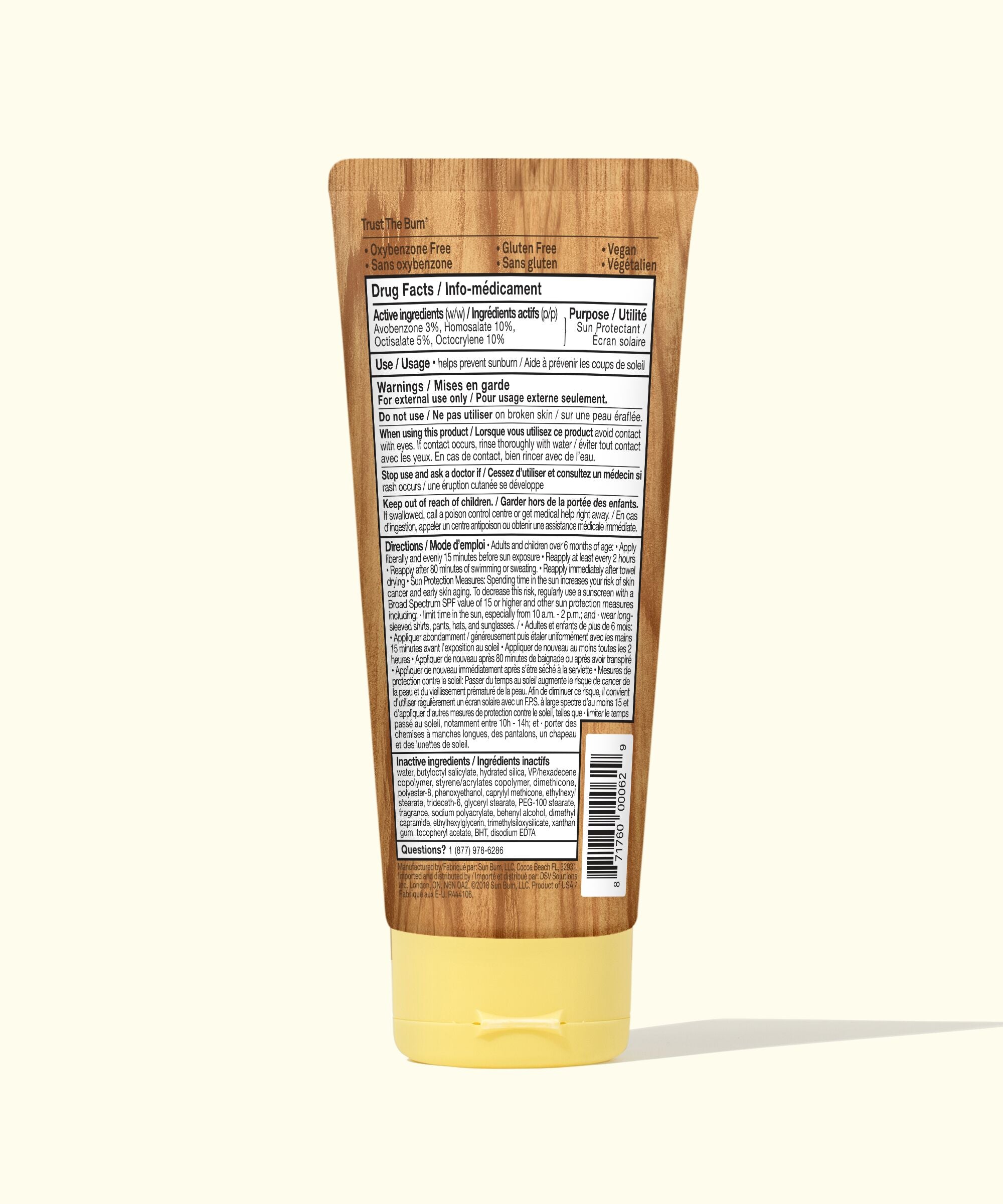 Tub of sunscreen with wooden applicator on a white background