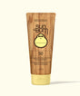 Sun Bum sunscreen tube with wooden texture and yellow cap on a white background