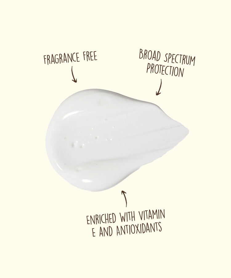 White skincare product with text indicating fragrance-free, broad spectrum protection, and vitamin E enrichment on a white background.