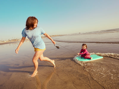 Two children playing on a beach with a clear sky