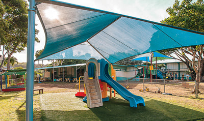 Children's playground with a blue slide and sunshade in an outdoor setting