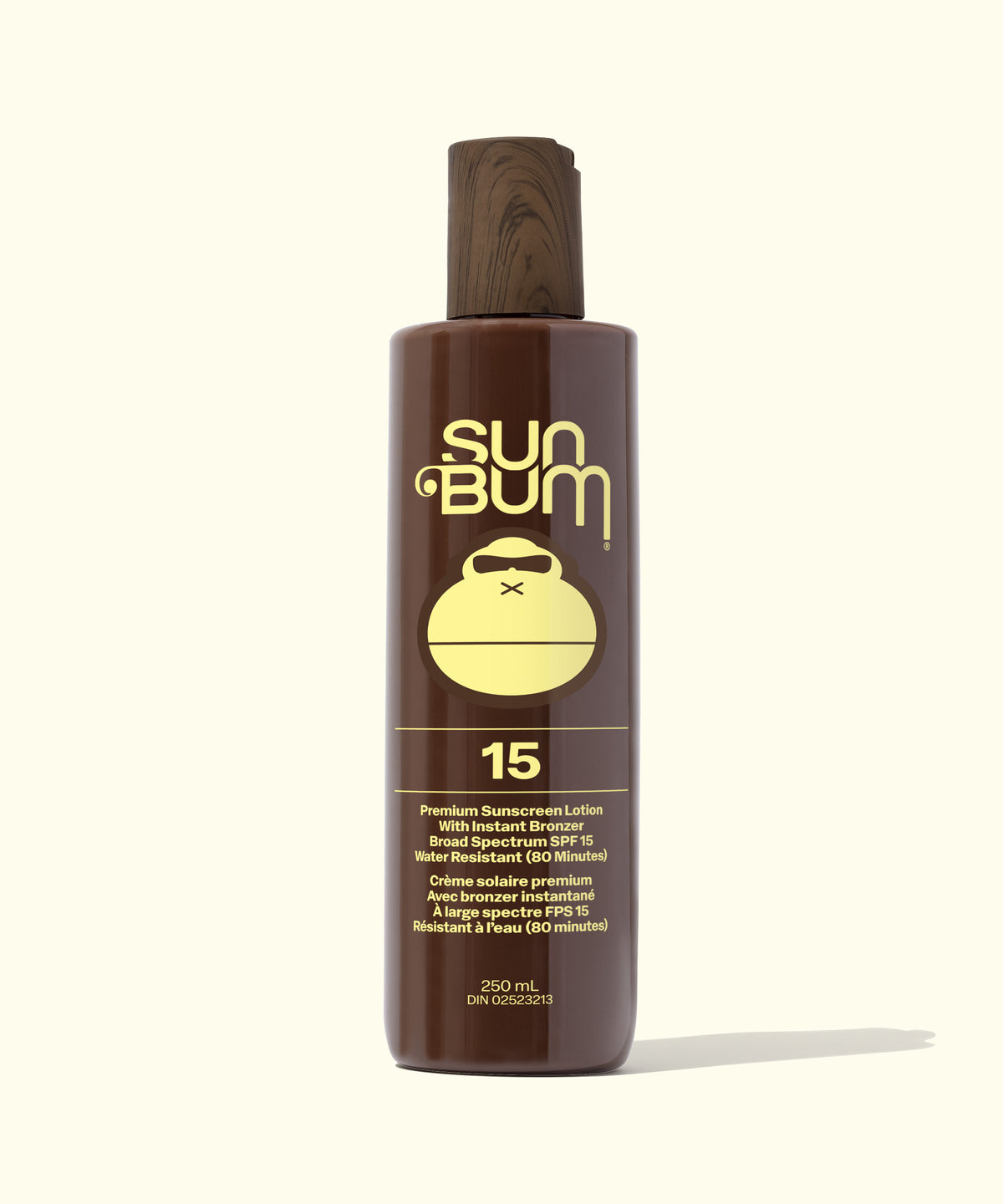 A single bottle of Sun Bum sunscreen lotion on a clean, solid off-white background. The bottle is dark brown with a matching dark brown cap, featuring a prominent yellow graphic of a kettlebell and the brand name 'Sun Bum' in yellow.