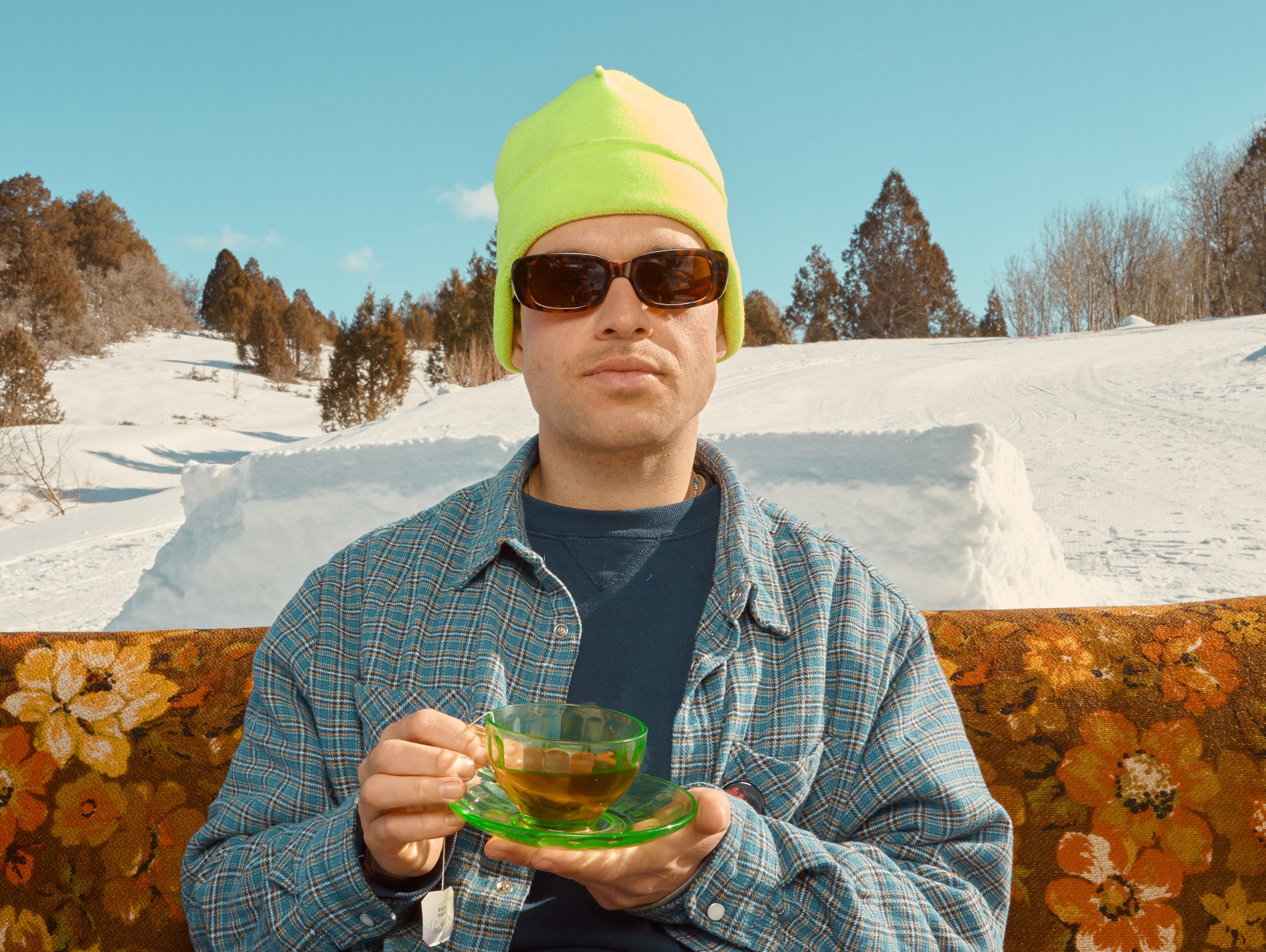 Person holding a cup of tea in a snowy landscape