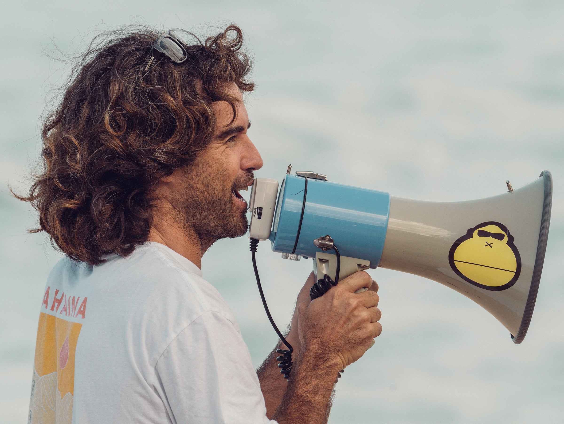 Man with a megaphone against a cloudy sky