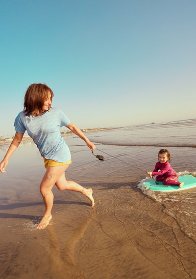 Woman and child playing on a beach with sand toys