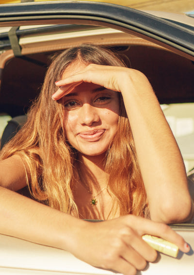 Woman sitting in a car with sunlight on her face