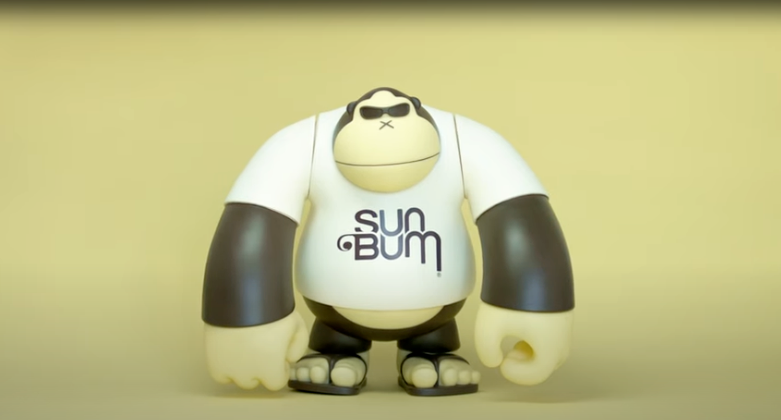 Toy figure with 'Sun Bum' t-shirt on a beige background