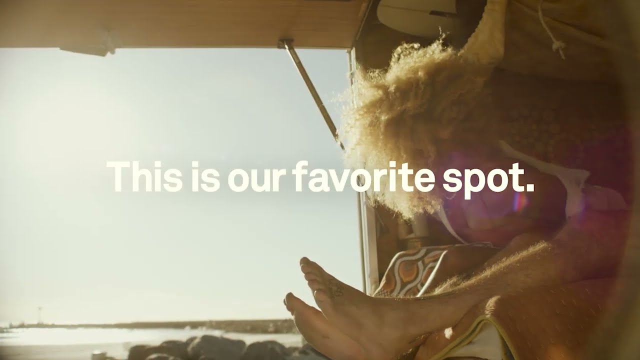 Person holding a phone with a scenic view and text 'This is our favorite spot.'